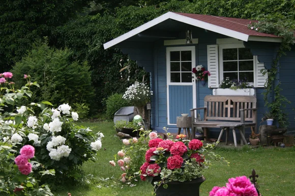 Blaues Gartenhaus mit Rosen